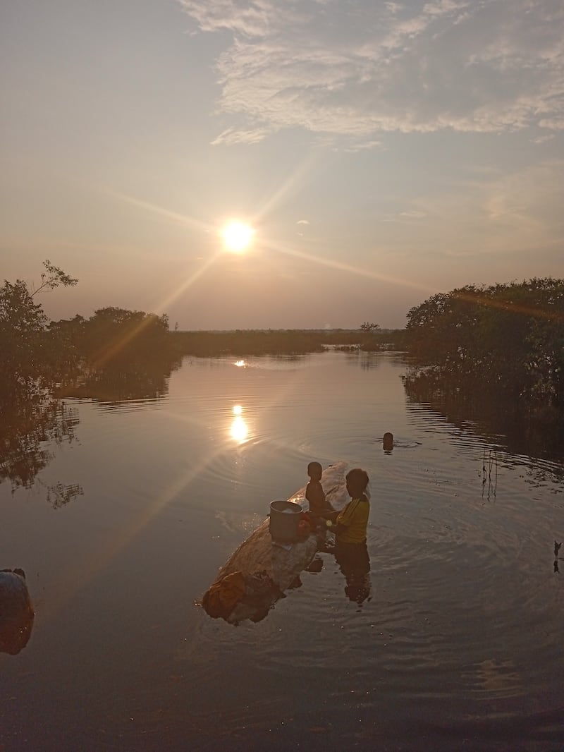 Mujer y su hijo en un caño de río.