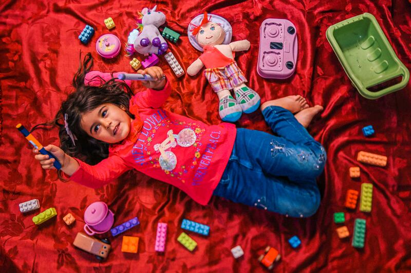 Arsal, Líbano, mayo de 2023. Siwar sostiene su pluma de insulina mientras está acostada entre sus juguetes en la casa improvisada de su familia en Arsal. Le diagnosticaron diabetes tipo 1 a una edad temprana y frecuenta la clínica de MSF en la ciudad para recibir tratamiento.